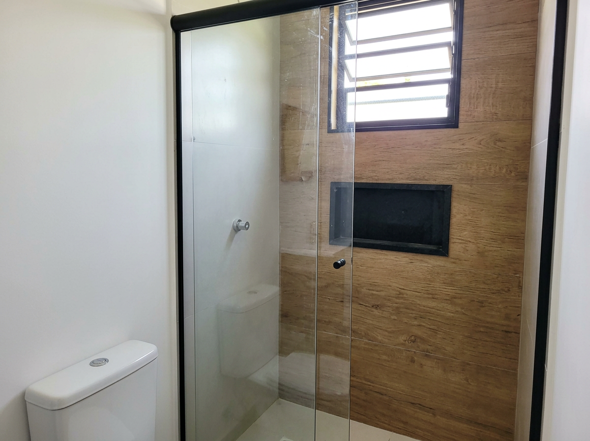 Banheiro com box de vidro e janela basculante