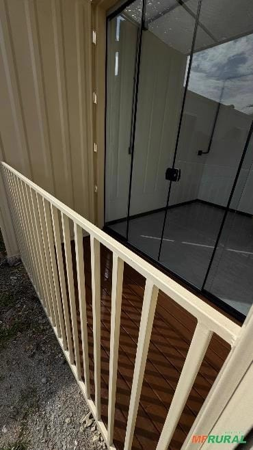 Detalhe da varanda com guarda-corpo e porta de vidro